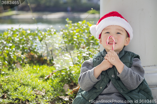 Image of Cute Mixed Race Boy With Santa Hat and Candy Cane