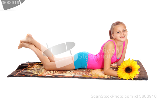 Image of Young girl lying in bathing suit on floor.