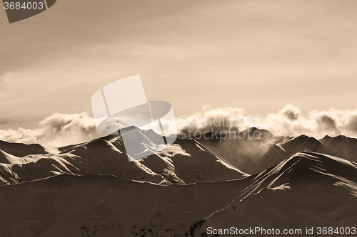 Image of Sepia evening winter mountains and sunlight clouds