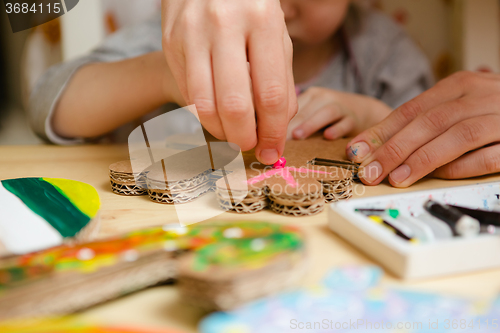 Image of Little female baby painting with colorful paints