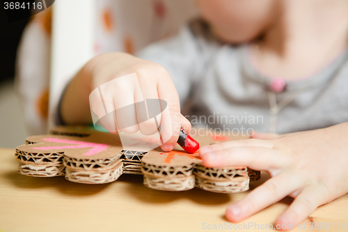Image of Little female baby painting with colorful paints