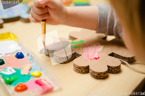 Image of Little female baby painting with colorful paints