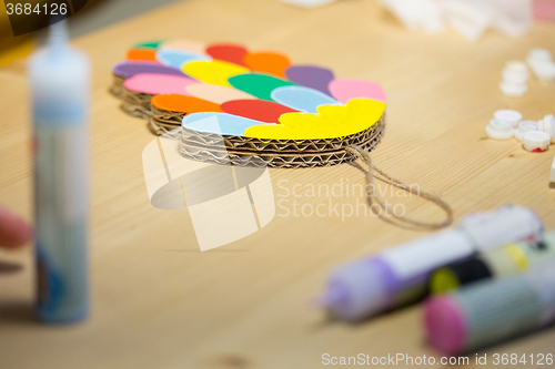 Image of Colorful toys made of cardboard on a wooden table.
