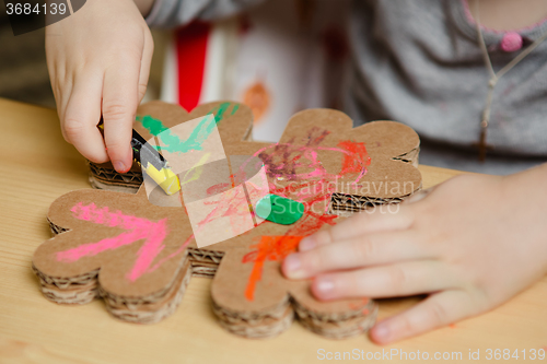 Image of Little female baby painting with colorful paints