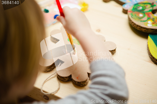Image of Little female baby painting with colorful paints