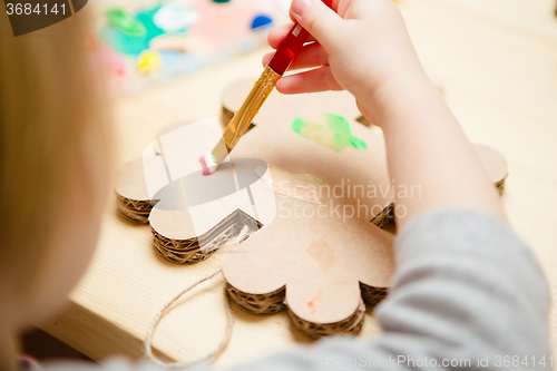 Image of Little female baby painting with colorful paints