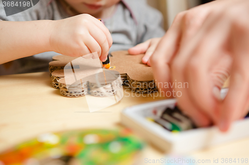 Image of Little female baby painting with colorful paints