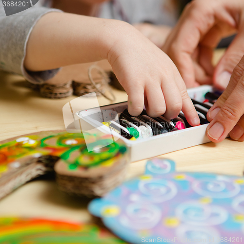 Image of Little female baby painting with colorful paints