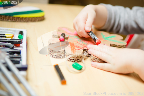 Image of Little female baby painting with colorful paints