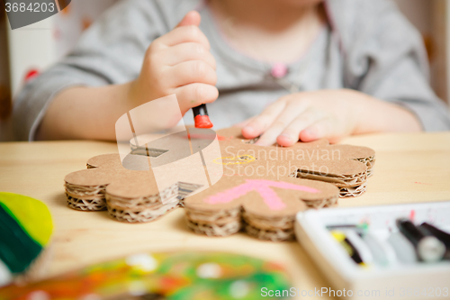 Image of Little female baby painting with colorful paints