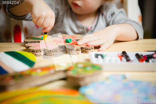 Image of Little female baby painting with colorful paints