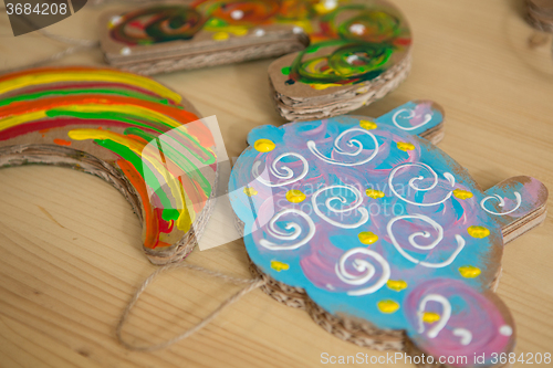 Image of Colorful toys made of cardboard on a wooden table.
