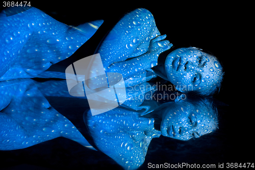 Image of The  body of woman with blue pattern and its reflection