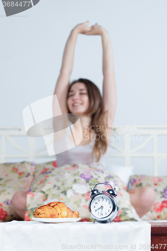 Image of The young girl in bed with  clock service