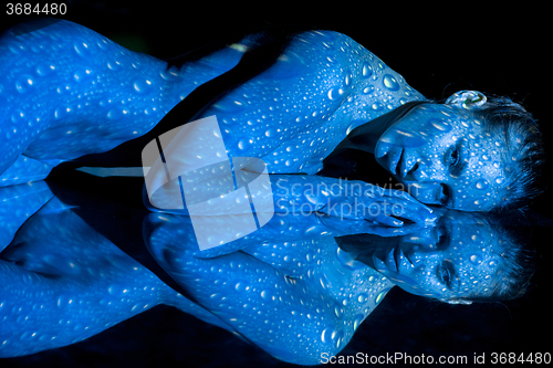 Image of The  body of woman with blue pattern and its reflection