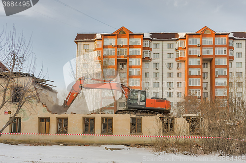 Image of Demolition of a house with an orange digger