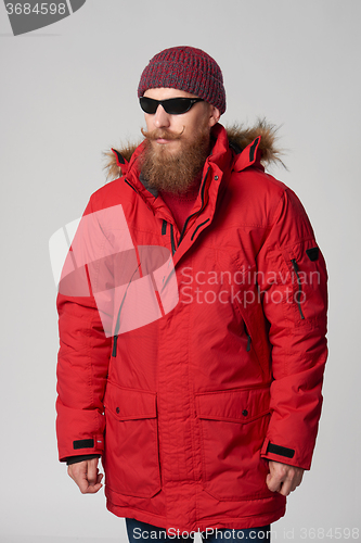 Image of Man wearing red winter Alaska jacket  with fur hood on