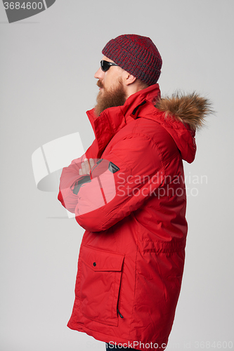 Image of Man wearing red winter Alaska jacket  with fur hood on