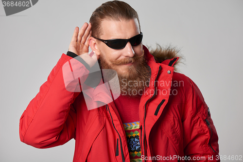 Image of Man wearing red winter Alaska jacket  with fur hood on