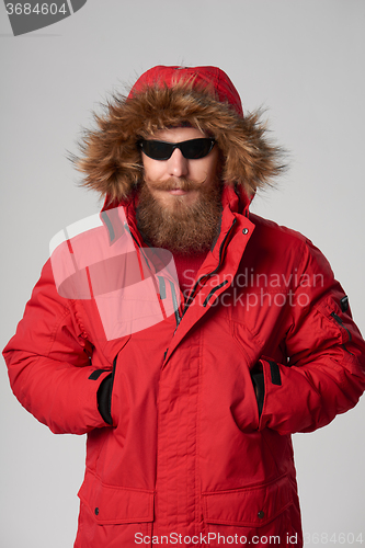 Image of Man wearing red winter Alaska jacket  with fur hood on