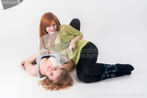 Image of Two attractive girls lie and have fun