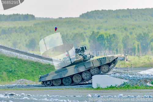 Image of Tank T-80 overcomes a high concrete obstacle