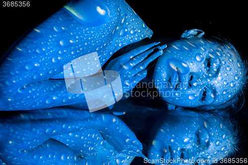 Image of The  body of woman with blue pattern and its reflection