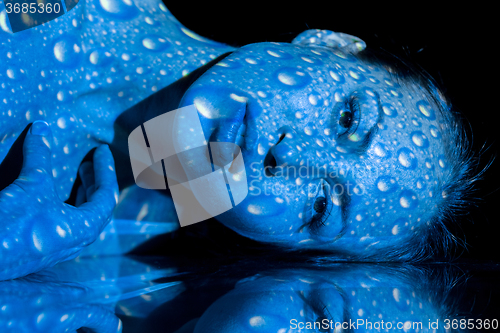 Image of The  body of woman with blue pattern and its reflection