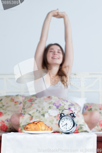 Image of The young girl in bed with  clock service