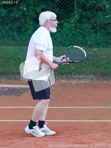 Image of Senior man playing tennis