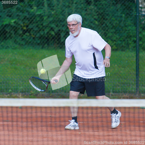 Image of Senior man playing tennis