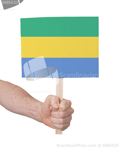 Image of Hand holding small card - Flag of Gabon