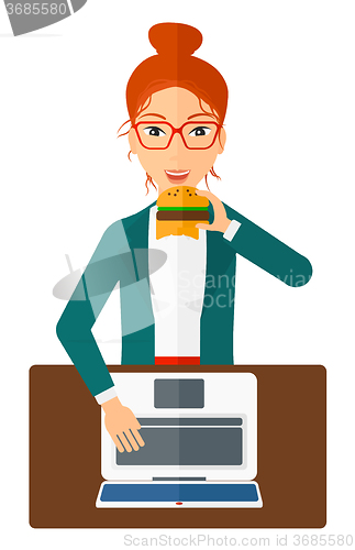 Image of Woman eating hamburger. 