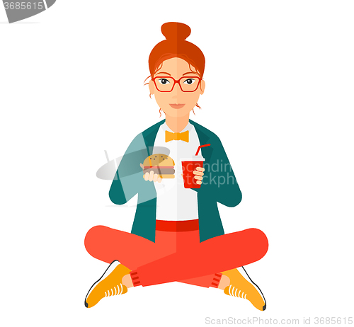 Image of Woman eating hamburger. 