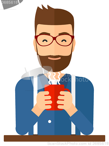 Image of Man sitting with cup of coffee.