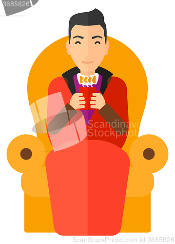 Image of Man sitting in chair with cup of tea.