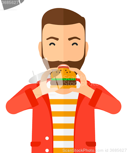 Image of Man eating hamburger. 