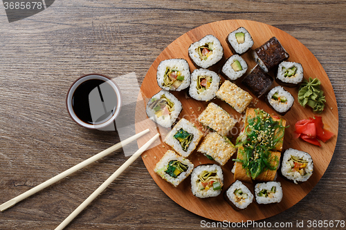 Image of Sushi set at round wooden plate 