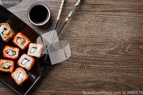 Image of Sushi roll with chopsticks