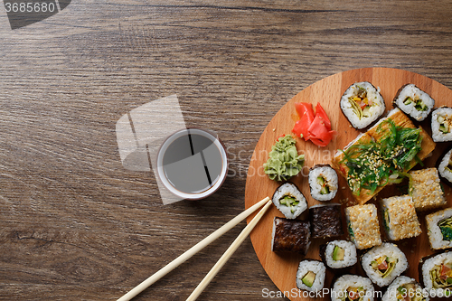 Image of Sushi set at round wooden plate 