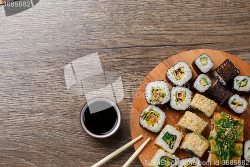 Image of Sushi set at round wooden plate 