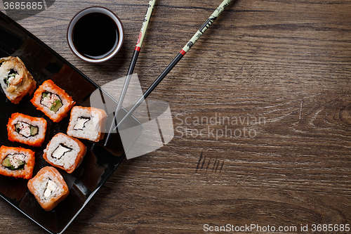 Image of Sushi roll with chopsticks