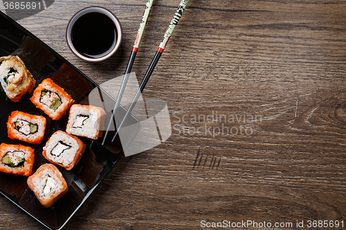 Image of Sushi roll with chopsticks