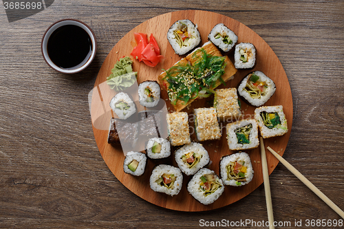 Image of Sushi set at round wooden plate 