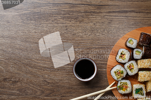 Image of Sushi set at round wooden plate 