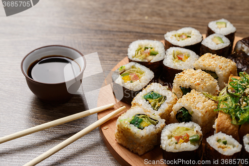 Image of Sushi set at round wooden plate 