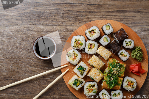 Image of Sushi set at round wooden plate 