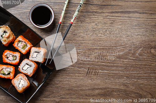 Image of Sushi roll with chopsticks