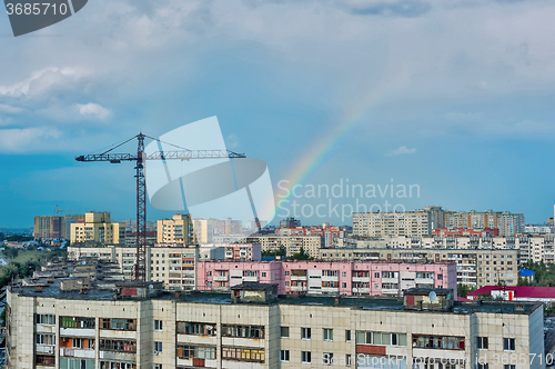 Image of Residential district with cranes and rainbow