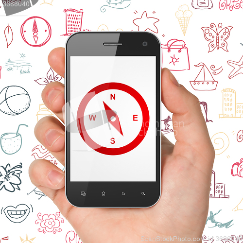 Image of Travel concept: Hand Holding Smartphone with Compass on display